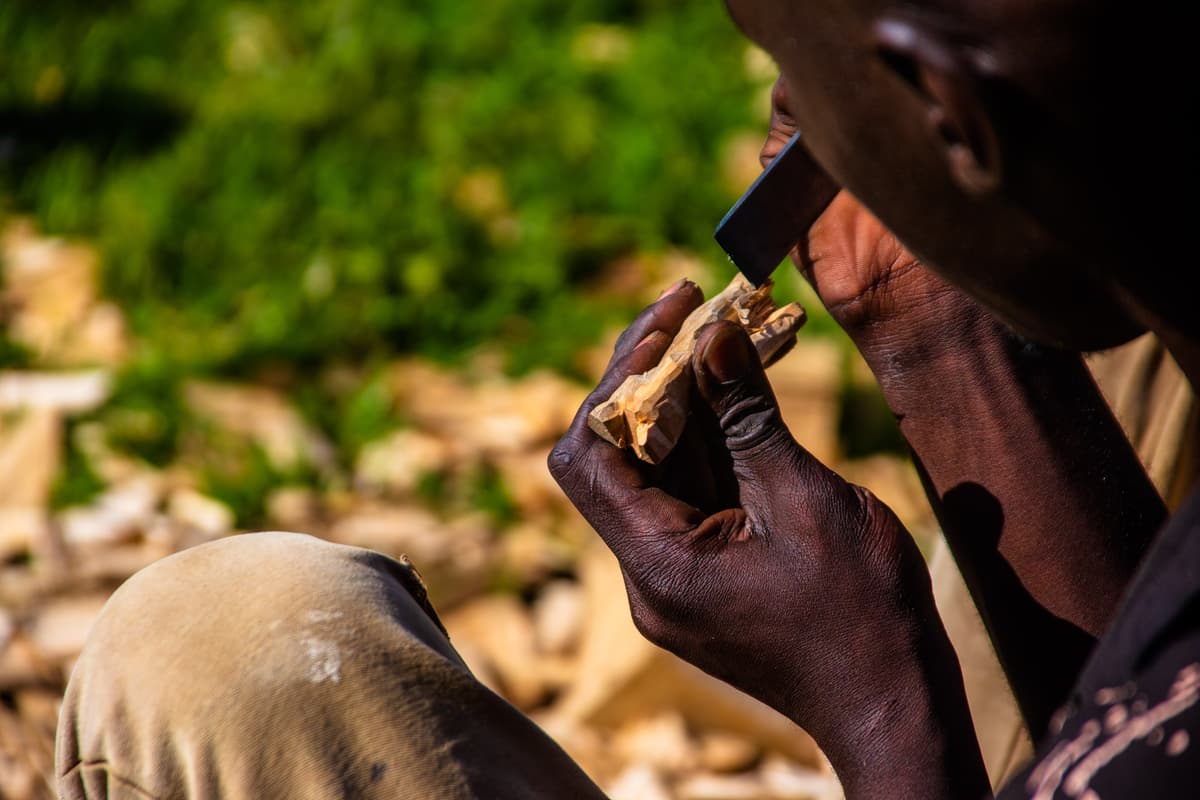A batwa man making a wood curving